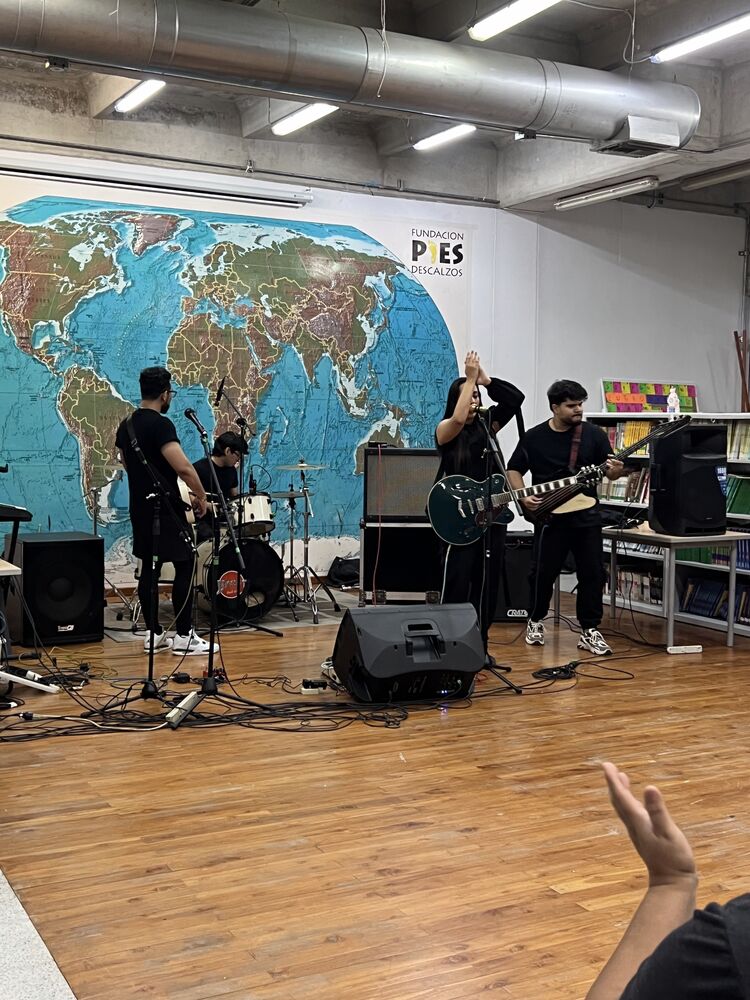 Banda en vivo frente al mapamundi en las audiciones intercolegiales